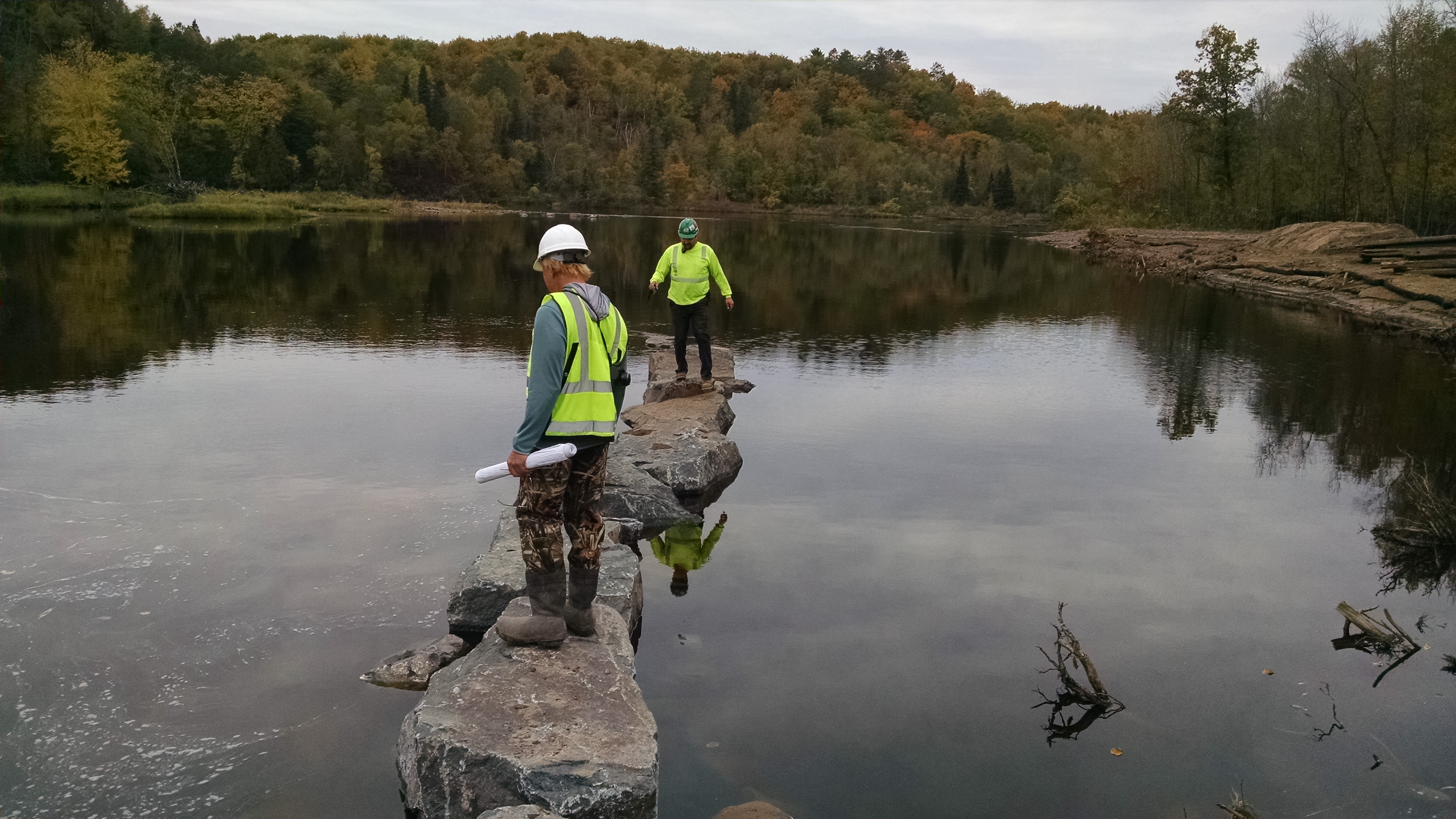 Two men stand on rocks in a NOAA Habitat Focus Area, the St. Louis River Estuary, which receives concentrated attention for several years.