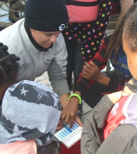 A crewmember on board the Sultana helps Dorchester County fifth graders determine how much dissolved oxygen is in Choptank River water.