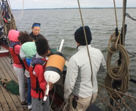 Students and crewmembers aboard the Sultana prepare to deploy a trawl.