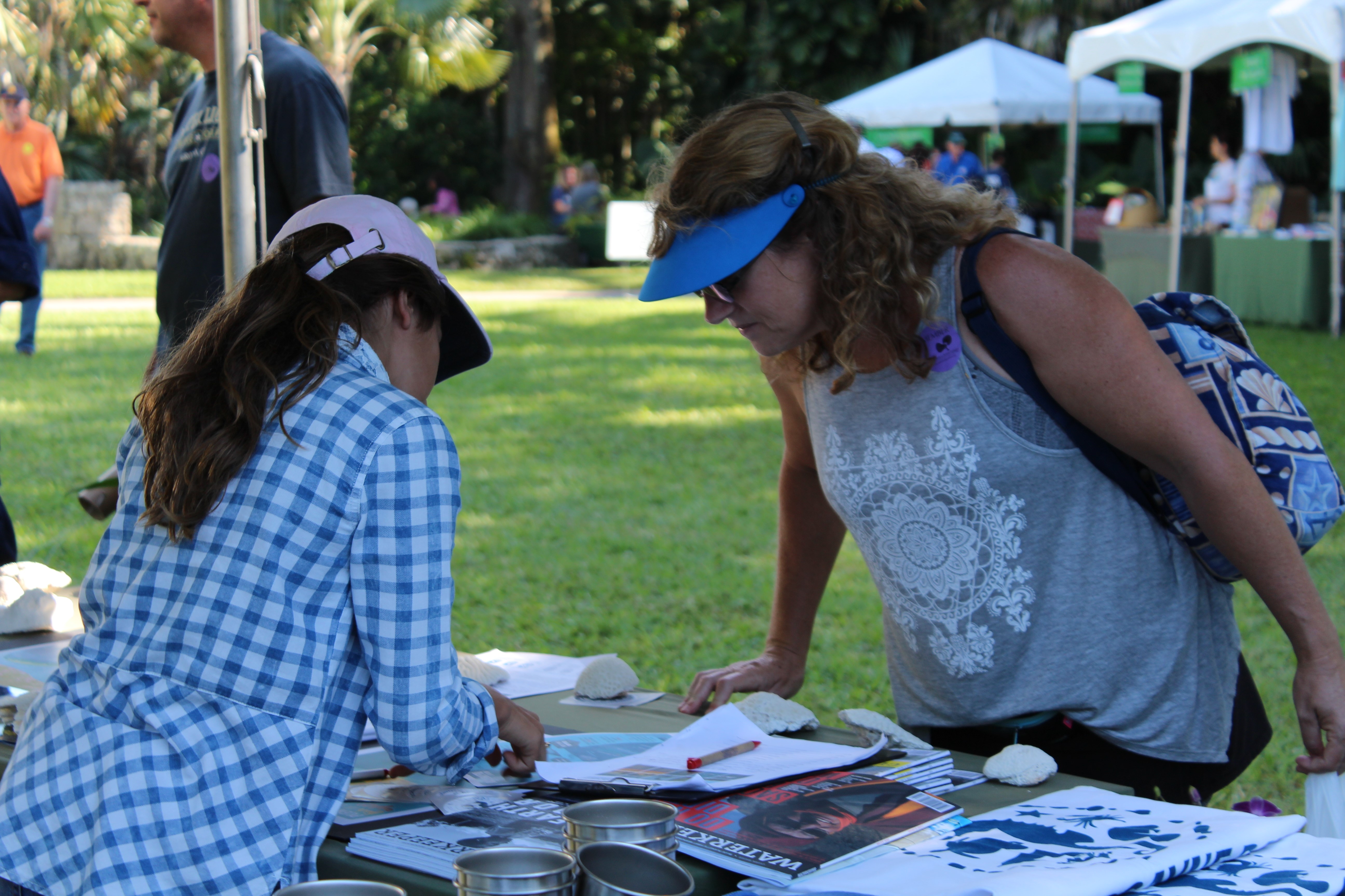 A Junior Ambassador educates a visitor about Biscayne Bay at a local outreach event.