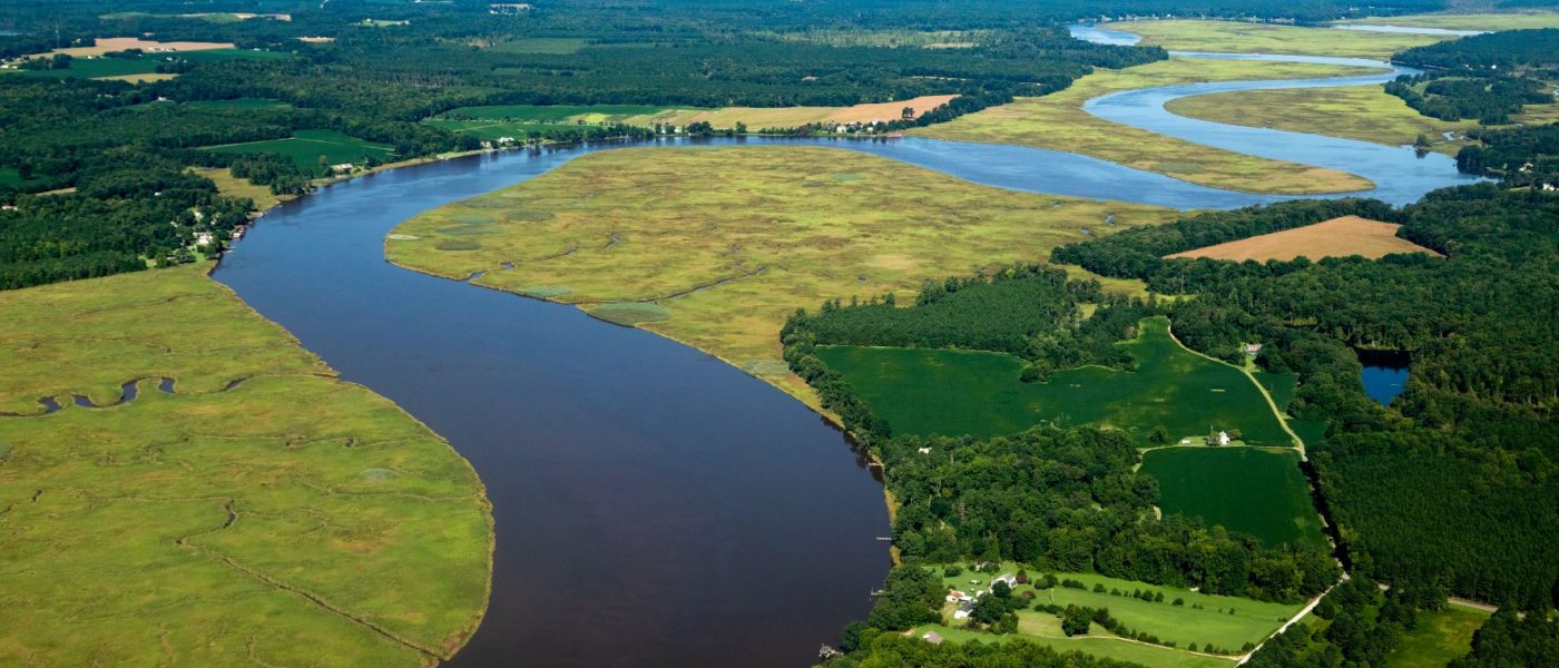 A river running through a low-lying patchwork landscape of farms, forests, and marshes. Credit: Chesapeake Bay Program